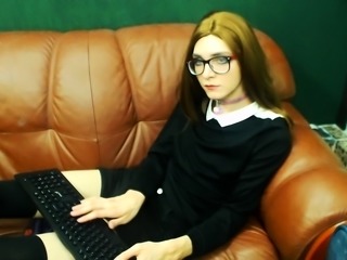 Nerdy young shemale in uniform pleases herself on the couch